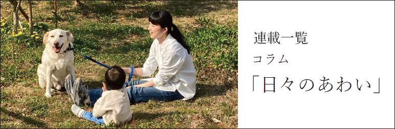 外でくつろぐ犬と母と子